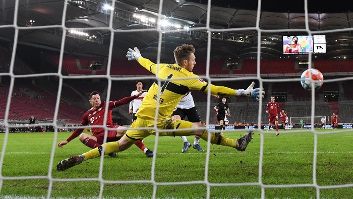 STUTTGART, GERMANY - DECEMBER 14: Robert Lewandowski of FC Bayern Muenchen scores their sides fourth goal past Florian Mueller of VfB Stuttgart during the Bundesliga match between VfB Stuttgart and FC Bayern München at Mercedes-Benz Arena on December 14, 2021 in Stuttgart, Germany. (Photo by Matthias Hangst/Getty Images)