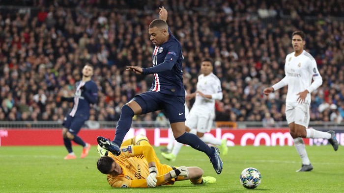 MADRID, SPAIN - NOVEMBER 26: Kylian Mbappe of Paris Saint-Germain is challenged by Thibaut Courtois of Real Madrid during the UEFA Champions League group A match between Real Madrid and Paris Saint-Germain at Bernabeu on November 26, 2019 in Madrid, Spain. (Photo by Angel Martinez/Getty Images)