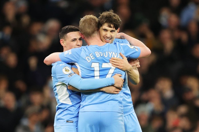 MANCHESTER, ENGLAND - DECEMBER 14: Kevin De Bruyne of Manchester City celebrates after scoring their sides fifth goal with Phil Foden and John Stones during the Premier League match between Manchester City and Leeds United at Etihad Stadium on December 14, 2021 in Manchester, England. (Photo by Clive Brunskill/Getty Images)