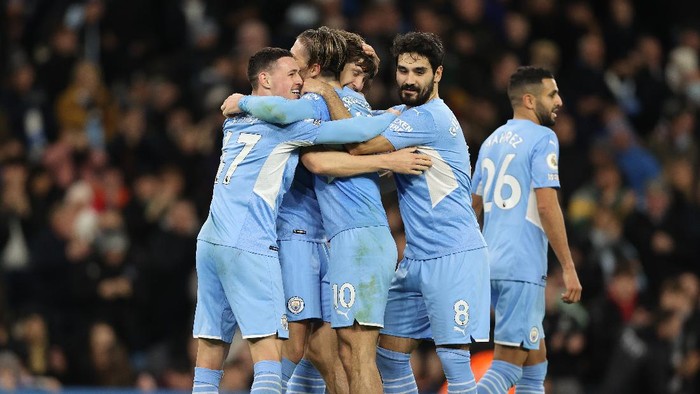 MANCHESTER, ENGLAND - DECEMBER 14: John Stones of Manchester City celebrates with Phil Foden and Jack Grealish after scoring their sides sixth goal during the Premier League match between Manchester City and Leeds United at Etihad Stadium on December 14, 2021 in Manchester, England. (Photo by Clive Brunskill/Getty Images)