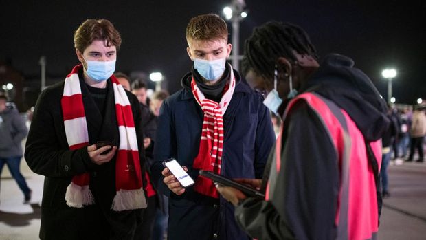 LONDON, ENGLAND - DECEMBER 15: Arsenal fans show their COVID-19 passes as part of the matchday protocols outside the stadium prior to the Premier League match between Arsenal and West Ham United at Emirates Stadium on December 15, 2021 in London, England. (Photo by Justin Setterfield/Getty Images)