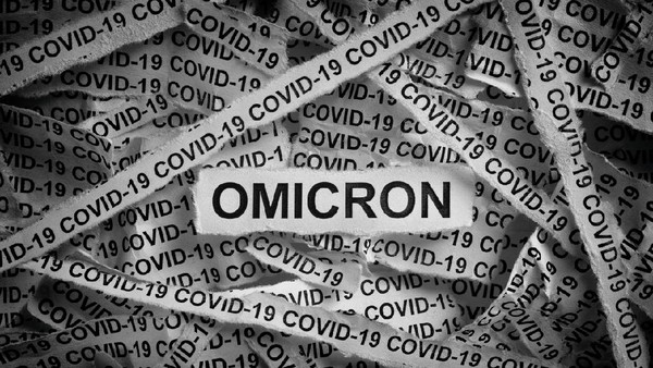 Pasien Omicron Pekerja di Wisma Atlet, Ini 5 Faktanya Strips of newspaper with the words Omicron and Covid-19 typed on them. Omicron variant of COVID-19. Black and white. Close up.