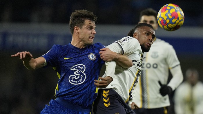 Chelseas Cesar Azpilicueta, left, challenges for the ball with Evertons Alex Iwobi during the English Premier League soccer match between Chelsea and Everton, at the Stamford Bridge stadium in London, Thursday, Dec.16, 2021. (AP Photo/Alastair Grant)