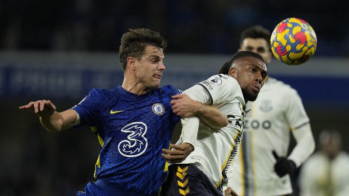 Chelseas Cesar Azpilicueta, left, challenges for the ball with Evertons Alex Iwobi during the English Premier League soccer match between Chelsea and Everton, at the Stamford Bridge stadium in London, Thursday, Dec.16, 2021. (AP Photo/Alastair Grant)