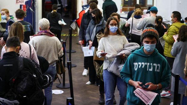 People queue at a coronavirus disease (COVID-19) vaccination centre in London, Britain, December 15, 2021. REUTERS/Hannah McKay
