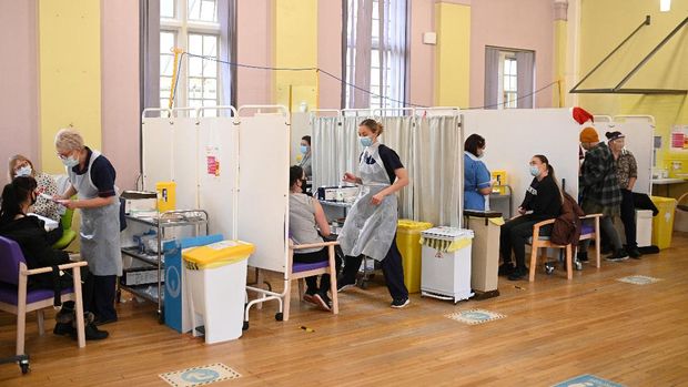 People wait to receive a dose of the Moderna Covid-19 vaccine at Babington Hospital in Belper on December 16, 2021 as the UK steps up the country's booster drive to fight a 