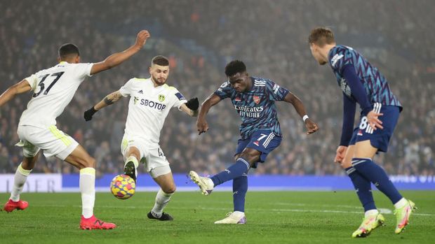 LEEDS, ENGLAND - DECEMBER 18: Bukayo Saka of Arsenal scores their team's third goal during the Premier League match between Leeds United  and  Arsenal at Elland Road on December 18, 2021 in Leeds, England. (Photo by Naomi Baker/Getty Images)