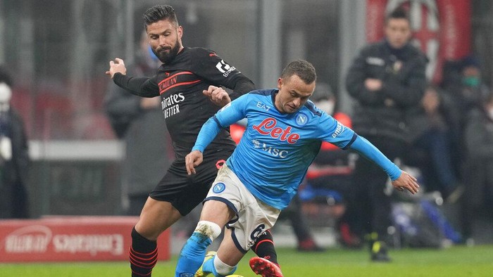 AC Milans Olivier Giroud, left, and Napolis Stanislav Lobotka challenge for the ball during the Serie A soccer match between AC Milan and Napoli at the San Siro stadium in Milan, Italy, Sunday, Dec. 19, 2021. (AP Photo/Antonio Calanni)