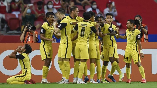 Malaysia's Kogileswaran Raj Mohana Raj (3R) celebrates with teammates after scoring a goal during the AFF Suzuki Cup 2020 Group B football match between Malaysia and Indonesia at the National Stadium in Singapore on December 19, 2021. (Photo by Roslan RAHMAN / AFP)