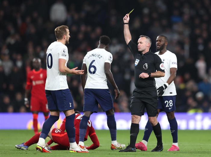 Harry Kane, Tottenham Hotspur, Liverpool LONDON, ENGLAND - DECEMBER 19: Harry Kane of Tottenham receives a yellow card for a foul on Andrew Robertson of Liverpoolduring the Premier League match between Tottenham Hotspur and Liverpool at Tottenham Hotspur Stadium on December 19, 2021 in London, England. (Photo by Alex Pantling/Getty Images )