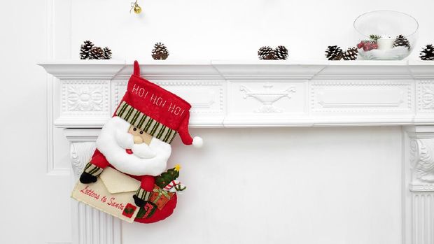 A close picture of beautifully decorated Santa Christmas socks with ho! ho! ho! word hanging on a fireplace waiting for presents