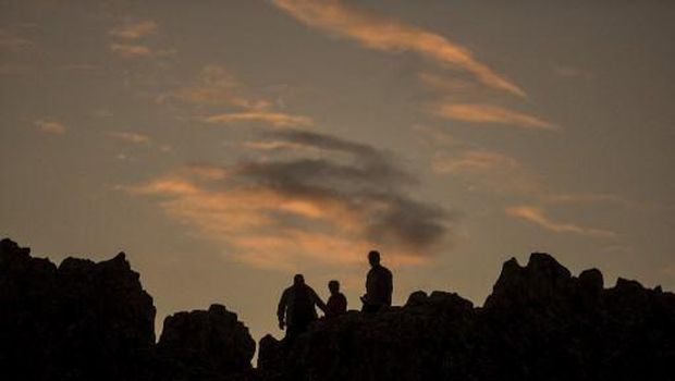 People stand on a rocky crest filled with astronomical markers at the megalithic observatory of Kokino, early on June 21, 2020 -- the day of the summer solstice. - The ancient astronomic observatory, located about 100 km northeast of Skopje, the capital of the Republic of Macedonia, dates more than 4.000 years back in time. It is ranked by NASA as the fourth ancient observatory in the world (Photo by Robert ATANASOVSKI / AFP)