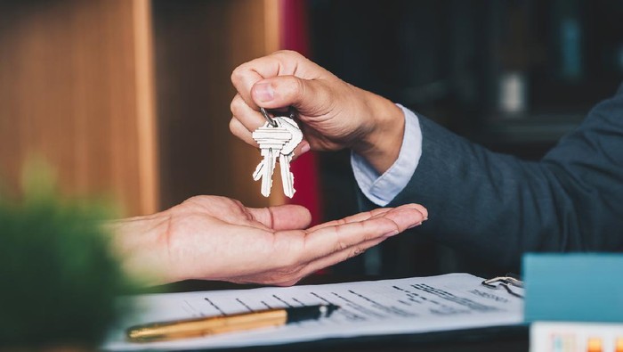 Ilustrasi Beli Rumah estate agent giving house keys to woman and sign agreement in office