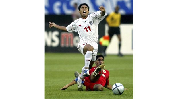 Bahrain's Mohamed Salmeen brings down Indonesia's Ponaryo Astaman (11) during their Asian Cup soccer match in Jinan, in China's eastern Shandong province, Sunday, July 25, 2004.  (AP Photo/Greg Baker)