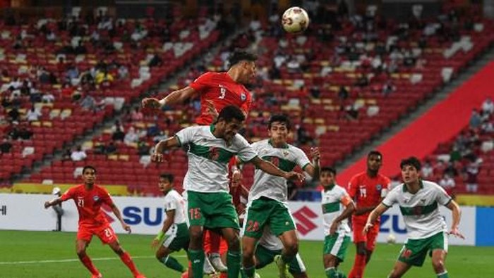 FBL-AFF-SIN-INA Singapore's Ikhsan Fandi (top) jumps to head the ball during the first leg of the AFF Suzuki Cup 2020 football semi-final match between Singapore and Indonesia at the National Stadium in Singapore on December 22, 2021. (Photo by Roslan RAHMAN / AFP)