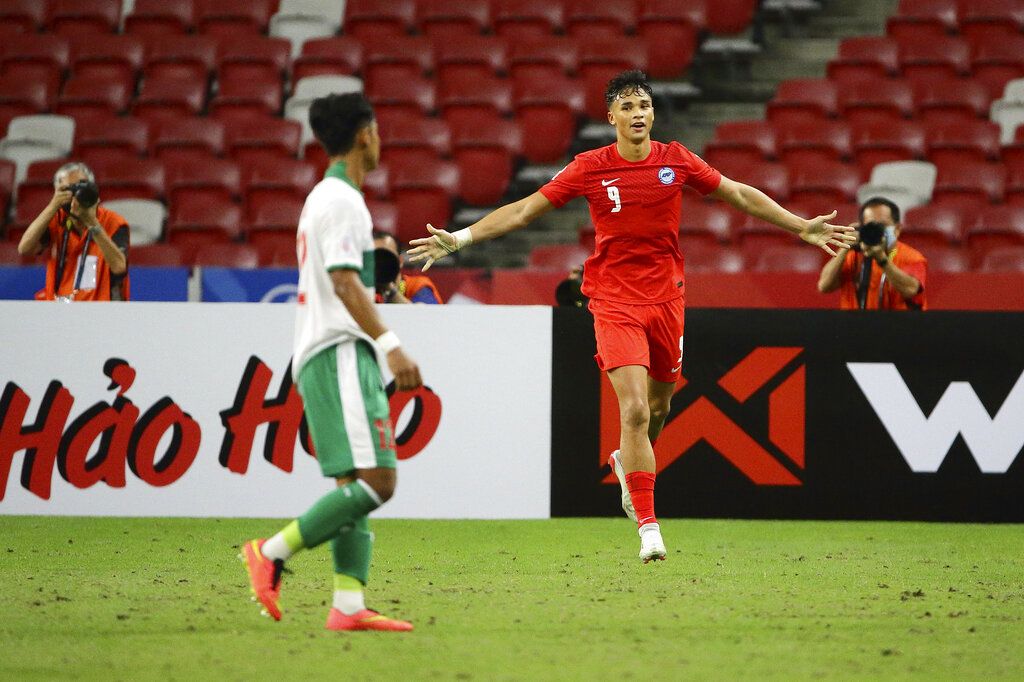 Ikhsan Fandi of Singapore, right, celebrates after scoring the equaliser during the AFF Suzuki Cup 2020 semi-final first leg soccer match between Singapore and Indonesia in Singapore, Wednesday, Dec. 22, 2021. (AP Photo/Suhaimi Abdullah)