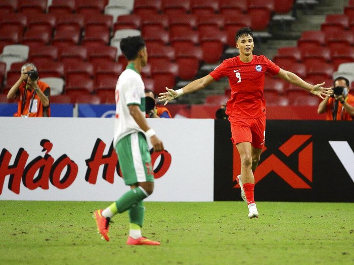 Ikhsan Fandi of Singapore, right, celebrates after scoring the equaliser during the AFF Suzuki Cup 2020 semi-final first leg soccer match between Singapore and Indonesia in Singapore, Wednesday, Dec. 22, 2021. (AP Photo/Suhaimi Abdullah)