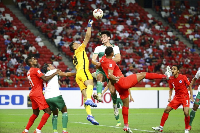 Hassan Sunny of Singapore, third left, and Elkan William Tio Baggott of Indonesia compete for the ball during the AFF Suzuki Cup 2020 semi-final first leg soccer match between Singapore and Indonesia in Singapore, Wednesday, Dec. 22, 2021. (AP Photo/Suhaimi Abdullah)