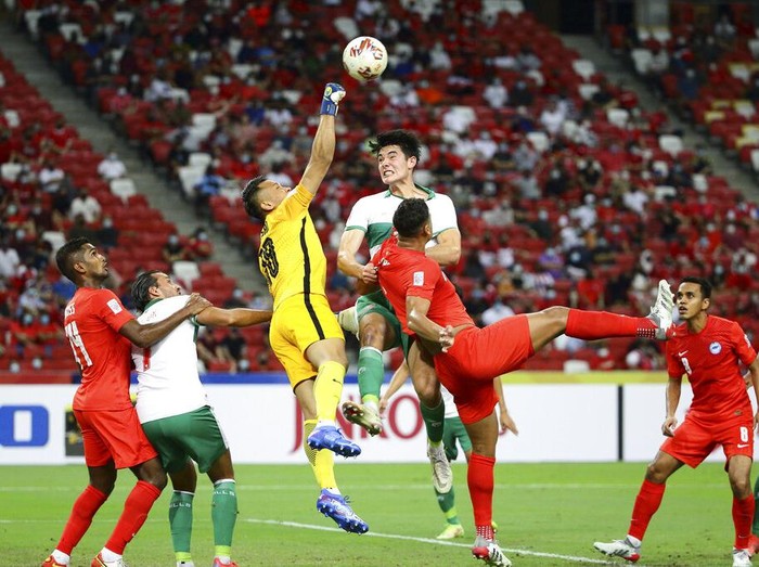 Hassan Sunny of Singapore, third left, and Elkan William Tio Baggott of Indonesia compete for the ball during the AFF Suzuki Cup 2020 semi-final first leg soccer match between Singapore and Indonesia in Singapore, Wednesday, Dec. 22, 2021. (AP Photo/Suhaimi Abdullah)