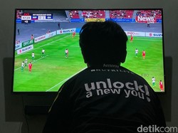 Beberapa warga menyaksikan pertandingan melalui televisi di rumah.