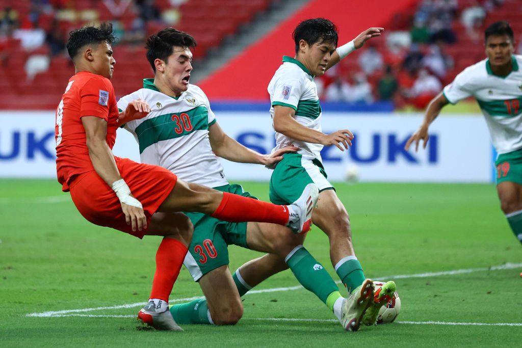 SINGAPORE, SINGAPORE - DECEMBER 22: Ikhsan Fandi #9 of Singapore shoots the ball against Elkan William Tio Baggot #30 and Alfeandra Dewangga Santosa #28 of Indonesia during the second half of the first leg of their AFF Suzuki Cup semifinal at the National Stadium on December 22, 2021 in Singapore. (Photo by Yong Teck Lim/Getty Images)