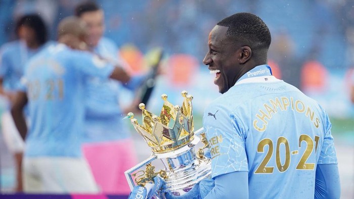 Benjamin Mendy MANCHESTER, ENGLAND - MAY 23: Benjamin Mendy of Manchester City celebrates with the Premier League Trophy as Manchester City are presented with the Trophy as they win the league following the Premier League match between Manchester City and Everton at Etihad Stadium on May 23, 2021 in Manchester, England. A limited number of fans will be allowed into Premier League stadiums as Coronavirus restrictions begin to ease in the UK. (Photo by Dave Thompson - Pool/Getty Images)