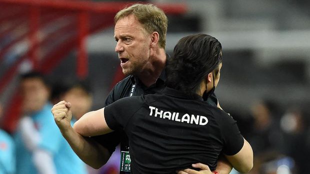 Thailand's head coach Alexandre Polking (L) celebrates after his team won the first leg of the AFF Suzuki Cup 2020 football semi-final match against Vietnam at the National Stadium in Singapore on December 23, 2021. (Photo by Roslan RAHMAN / AFP)