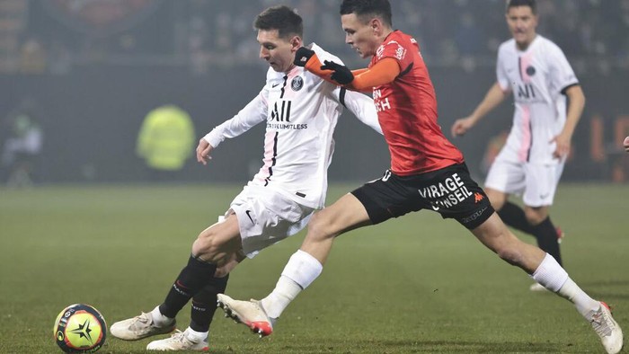 PSGs Lionel Messi, left, and Lorients Enzo Le Fee challenge for the ball during the French League One soccer match between FC Lorient and Paris Saint-Germain at the Moustoir stadium in Lorient, western France, Wednesday, Dec. 22, 2021. (AP Photo/Jeremias Gonzalez)