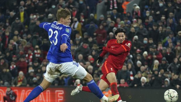 Liverpool's Takumi Minamino, right, shoots to score his sides third goal past Leicester's Jannik Vestergaard during the English League Cup quarter-final soccer match between Liverpool and Leicester City, at Anfield Stadium, in Liverpool, England, Wednesday Dec. 22, 2021. (AP Photo/Jon Super)