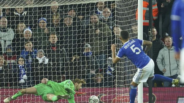 Liverpool's goalkeeper Caoimhin Kelleher, left, makes a save against Leicester's Ryan Bertrand during the penalty shootout of the English League Cup quarter-final soccer match between Liverpool and Leicester City, at Anfield Stadium, in Liverpool, England, Wednesday Dec. 22, 2021. (AP Photo/Jon Super)