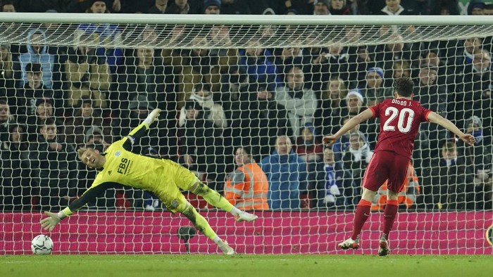 Liverpools Diogo Jota, right, scores the winning penalty past Leicesters goalkeeper Kasper Schmeichel of the penalty shootout of the English League Cup quarter-final soccer match between Liverpool and Leicester City, at Anfield Stadium, in Liverpool, England, Wednesday Dec. 22, 2021. (AP Photo/Jon Super)