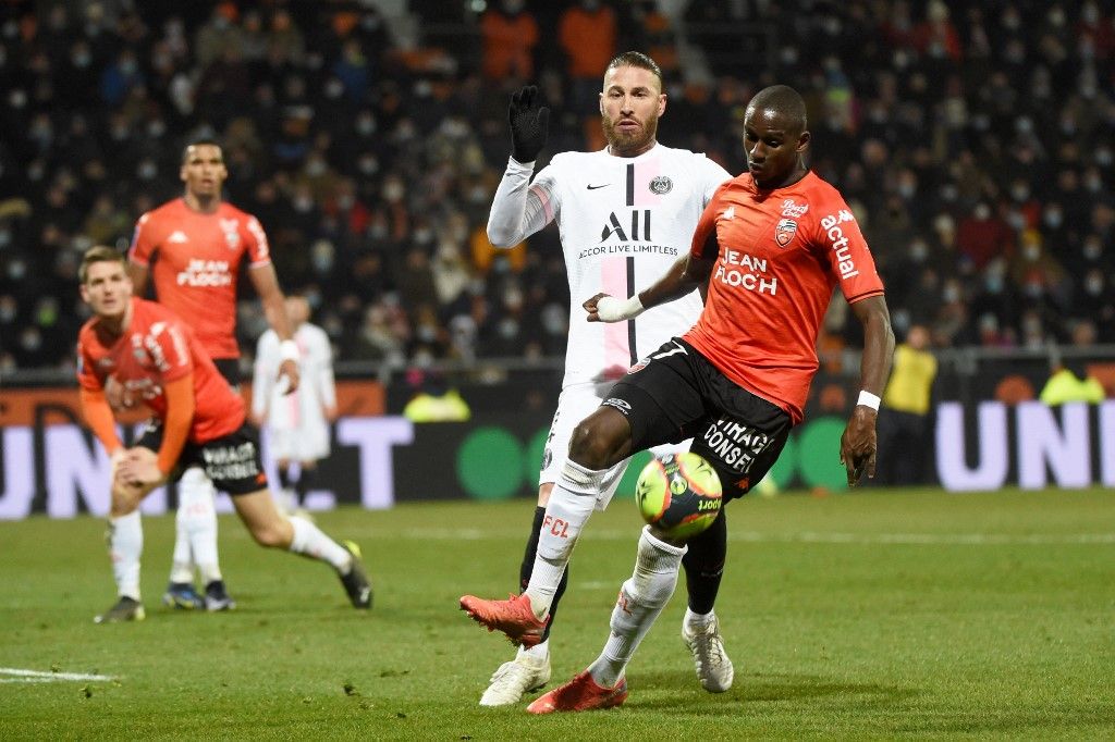 Lorient's French defender Houboulang Mendes (R) fights for the ball with Paris Saint-Germain's Spanish defender Sergio Ramos (C) during the French L1 football match between FC Lorient and Paris Saint-Germain at the Yves Allainmat-Le Moustoir Stadium in Lorient, western France, on December 22, 2021. (Photo by JEAN-FRANCOIS MONIER / AFP)