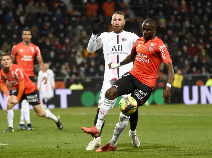 Lorient's French defender Houboulang Mendes (R) fights for the ball with Paris Saint-Germain's Spanish defender Sergio Ramos (C) during the French L1 football match between FC Lorient and Paris Saint-Germain at the Yves Allainmat-Le Moustoir Stadium in Lorient, western France, on December 22, 2021. (Photo by JEAN-FRANCOIS MONIER / AFP)
