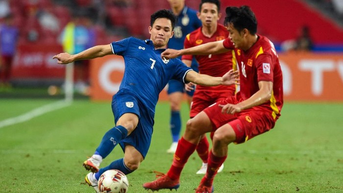 Thailands Supachok Sarachat (L) fights for the ball with Vietnams Nguyen Thanh Chung during the first leg of the AFF Suzuki Cup 2020 football semi-final match between Vietnam and Thailand at the National Stadium in Singapore on December 23, 2021. (Photo by Roslan RAHMAN / AFP)
