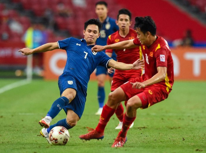 Thailands Supachok Sarachat (L) fights for the ball with Vietnams Nguyen Thanh Chung during the first leg of the AFF Suzuki Cup 2020 football semi-final match between Vietnam and Thailand at the National Stadium in Singapore on December 23, 2021. (Photo by Roslan RAHMAN / AFP)