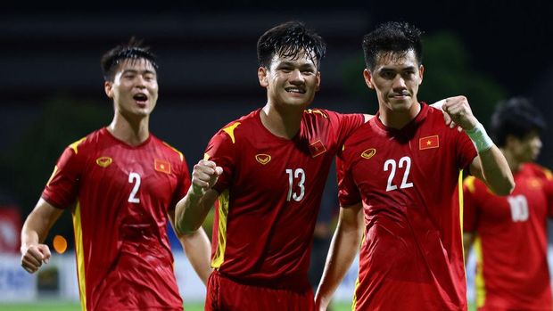 SINGAPORE, SINGAPORE - DECEMBER 19: Nguyen Tien Linh #22 of Vietnam celebrates with teammates Do Duy Manh #2 and Ho Tan Tai #13 after scoring a brace against Cambodia during the first half of their AFF Suzuki Cup Group B game at Bishan Stadium on December 19, 2021 in Singapore. (Photo by Yong Teck Lim/Getty Images)