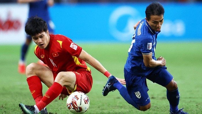 SINGAPORE, SINGAPORE - DECEMBER 23: Chanathip Songkrasin #18 of Thailand competes for the ball against Nguyen Hoang Duc #14 of Vietnam during the second half of the first leg of their AFF Suzuki Cup semifinal at the National Stadium on December 23, 2021 in Singapore. (Photo by Yong Teck Lim/Getty Images)