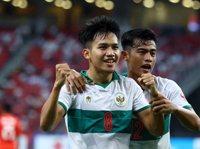 SINGAPORE, SINGAPORE - DECEMBER 22: Witan Sulaeman #8 of Indonesia celebrates with Pratama Arhan Alif Rifai #12 after scoring their first goal against Singapore during the first half of the first leg of their AFF Suzuki Cup semifinal at the National Stadium on December 22, 2021 in Singapore. (Photo by Yong Teck Lim/Getty Images)