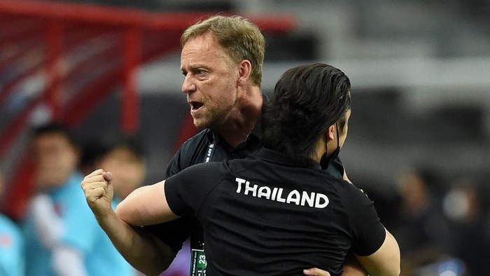 Thailands head coach Alexandre Polking (L) celebrates after his team won the first leg of the AFF Suzuki Cup 2020 football semi-final match against Vietnam at the National Stadium in Singapore on December 23, 2021. (Photo by Roslan RAHMAN / AFP)