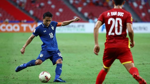 SINGAPORE, SINGAPORE - DECEMBER 23: Chanathip Songkrasin #18 of Thailand passes the ball against Phan Van Duc #20 of Vietnam during the second half of the first leg of their AFF Suzuki Cup semifinal at the National Stadium on December 23, 2021 in Singapore. (Photo by Yong Teck Lim/Getty Images)