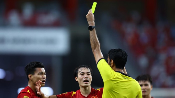 SINGAPORE, SINGAPORE - DECEMBER 23: Vu Van Thanh #17 of Vietnam is issued a yellow card after a play during the first half of the first leg of the AFF Suzuki Cup semifinal against Thailand at the National Stadium on December 23, 2021 in Singapore. (Photo by Yong Teck Lim/Getty Images)