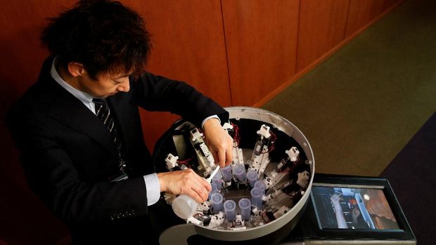 Meiji University professor Homei Miyashita fills flavour canisters as he demonstrates Taste the TV (TTTV), a prototype lickable TV screen that can imitate the flavours of various foods, at the university in Tokyo, Japan, December 22, 2021. Picture taken on December 22, 2021.   REUTERS/Kim Kyung-Hoon