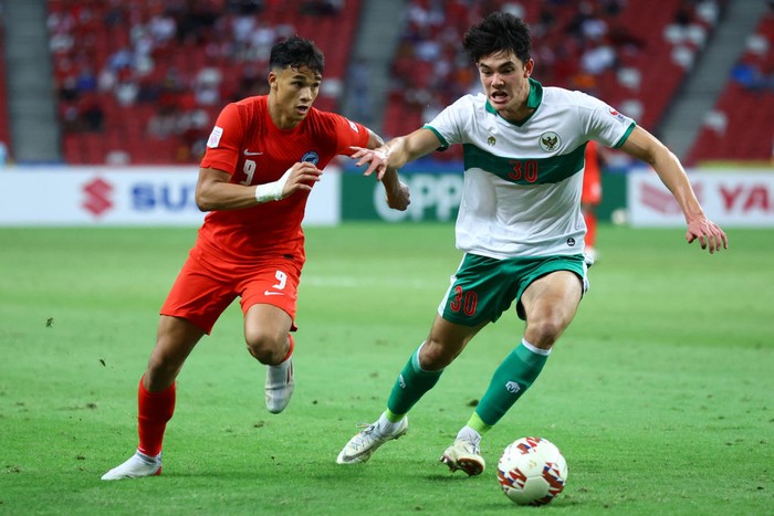 SINGAPORE, SINGAPORE - DECEMBER 22: Ikhsan Fandi #9 of Singapore competes for the ball against Elkan William Tio Baggot #30 of Indonesia during the second half of the first leg of their AFF Suzuki Cup semifinal at the National Stadium on December 22, 2021 in Singapore. (Photo by Yong Teck Lim/Getty Images)