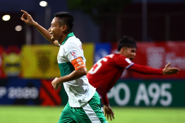 SINGAPORE, SINGAPORE - DECEMBER 12: Evan Dimas Darmono #6 of Indonesia celebrates after scoring his teams fifth goal as Loungleuang Keophouvong #25 of Laos reacts during the second half of their AFF Suzuki Cup Group B game at Bishan Stadium on December 12, 2021 in Singapore. (Photo by Yong Teck Lim/Getty Images)