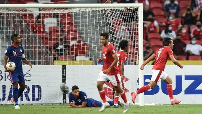 Indonesias Ezra Harm Ruud Walian (R) scores during the second leg of the AFF Suzuki Cup 2020 football semi-final match between Singapore and Indonesia at the National Stadium in Singapore on December 25, 2021. (Photo by Roslan RAHMAN / AFP)