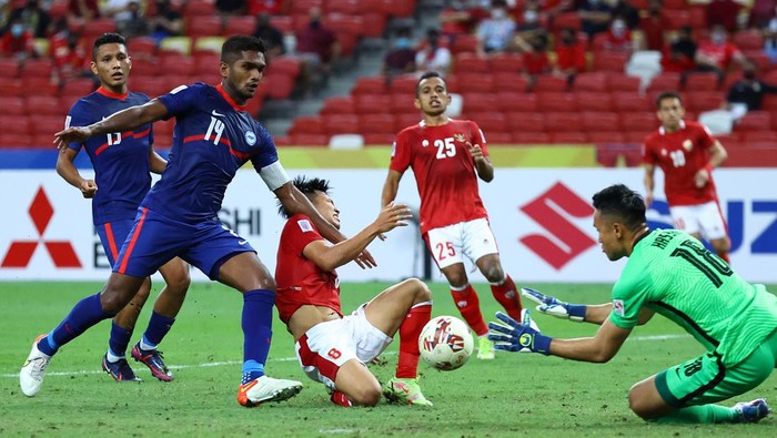 SINGAPORE, SINGAPORE - DECEMBER 25: Goalkeeper Hassan Sunny #18 of Singapore saves an attempt by Witan Sulaeman #8 of Indonesia during the second half of the second leg of their AFF Suzuki Cup semifinal at the National Stadium on December 25, 2021 in Singapore. (Photo by Yong Teck Lim/Getty Images)