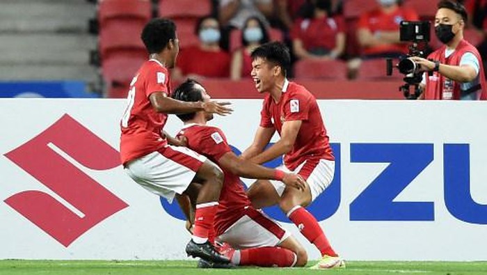Indonesias Ezra Harm Ruud Walian (C) is congratulated by teammates after scoring during the second leg of the AFF Suzuki Cup 2020 football semi-final match between Singapore and Indonesia at the National Stadium in Singapore on December 25, 2021. (Photo by Roslan RAHMAN / AFP)