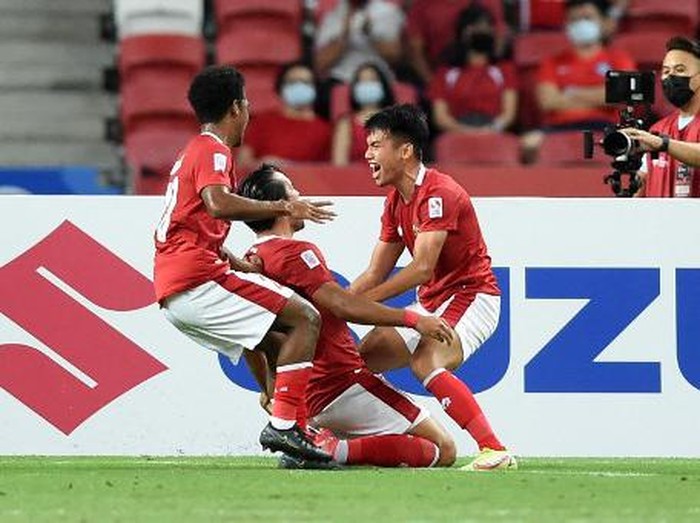 Indonesias Ezra Harm Ruud Walian (C) is congratulated by teammates after scoring during the second leg of the AFF Suzuki Cup 2020 football semi-final match between Singapore and Indonesia at the National Stadium in Singapore on December 25, 2021. (Photo by Roslan RAHMAN / AFP)