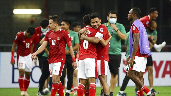 Asnawi Mangkualam of Indonesia, right, hugs Evan Dimas Darmono of Indonesia after defeating Singapore during the AFF Suzuki Cup 2020 semi-final second leg match between Indonesia and Singapore in Singapore, Saturday, Dec. 25, 2021. (AP Photo/Suhaimi Abdullah)