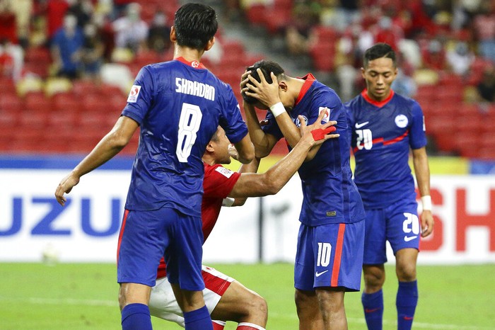 Asnawi Mangkualam of Indonesia, second left, gestures at Faris Ramli of Singapore after missing the penalty during the AFF Suzuki Cup 2020 semi-final second leg match between Indonesia and Singapore in Singapore, Saturday, Dec. 25, 2021. (AP Photo/Suhaimi Abdullah)